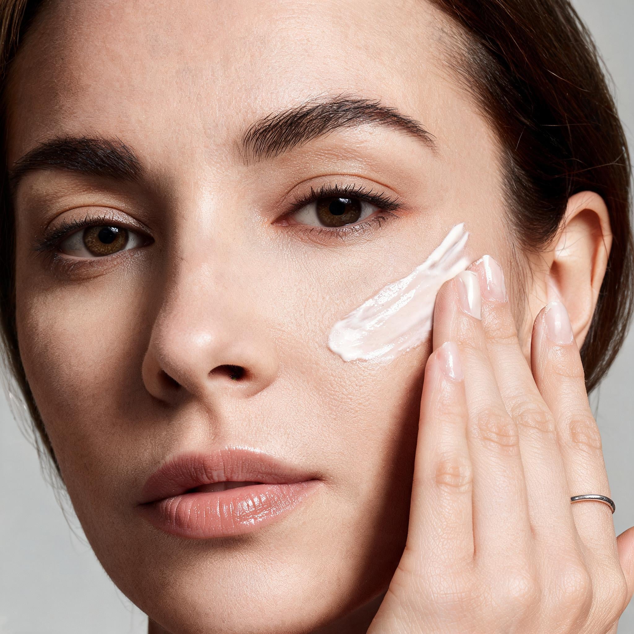 A model with a swatch of white Matrixyl 3000 Pro-Collagen cream on her cheek - Skingenetix customer review