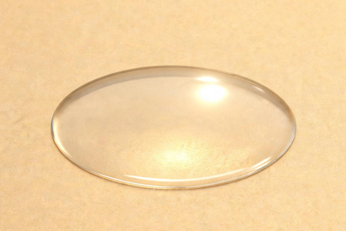 A shallow pool of clear liquid on a champagne-gold surface