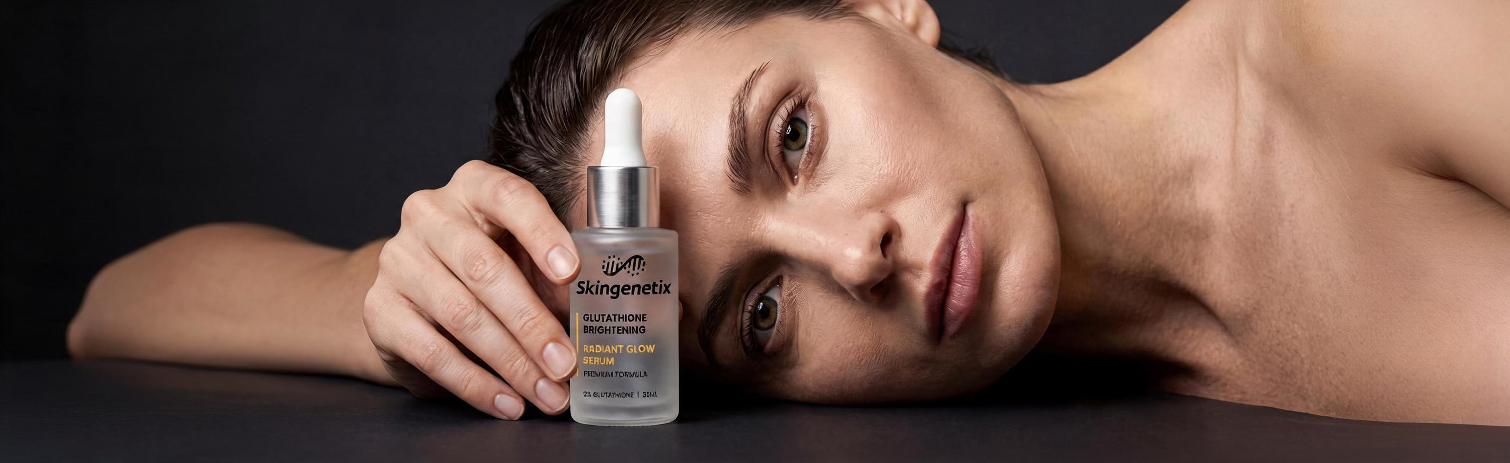 Eine Frau liegt seitlich und schaut in die Kamera, sie hält das Skingenetix Glutathione 2% Brightening Serum