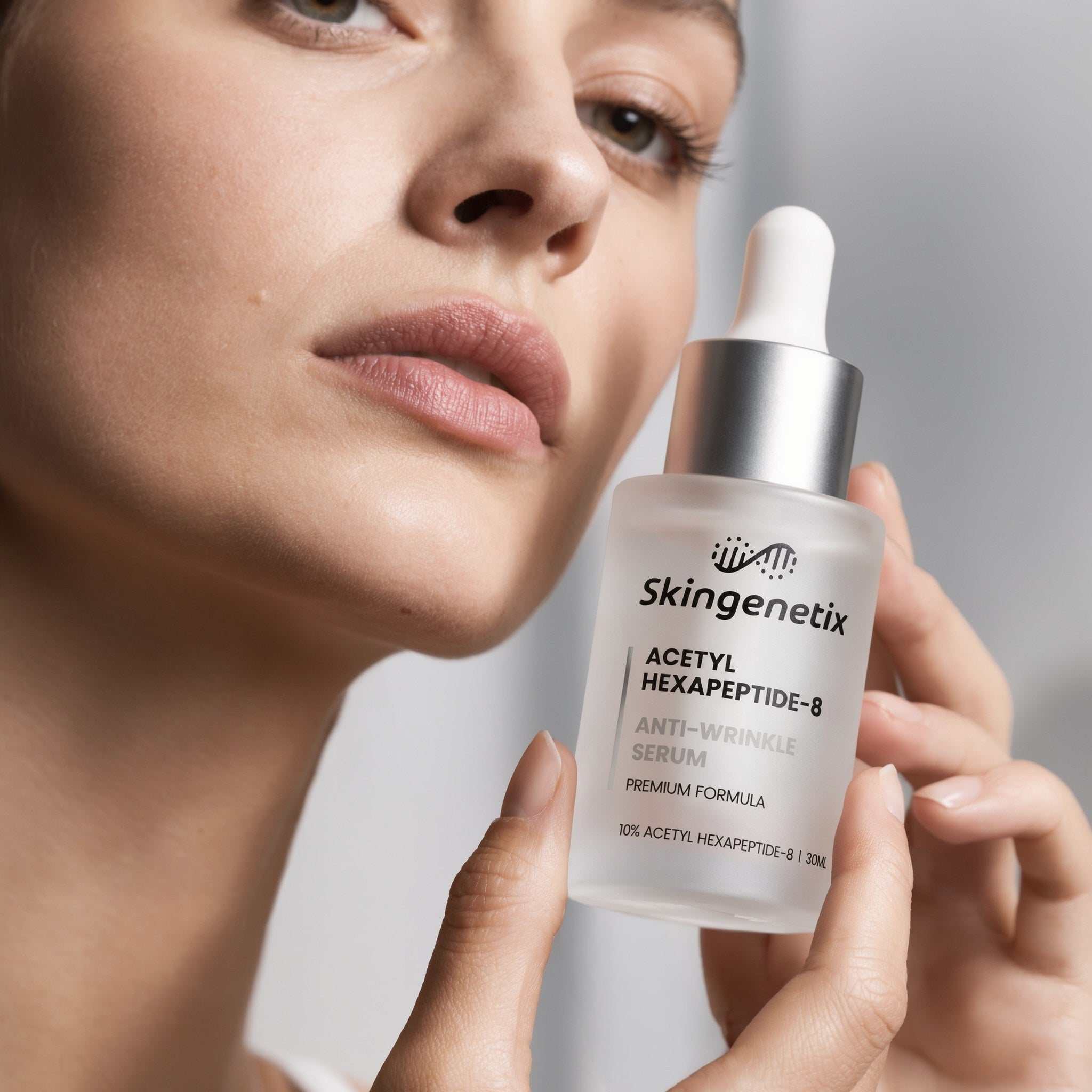 Skingenetix Acetyl Hexapeptide-8 Anti-Wrinkle Serum, 30ml - a model holding the bottle beside their face