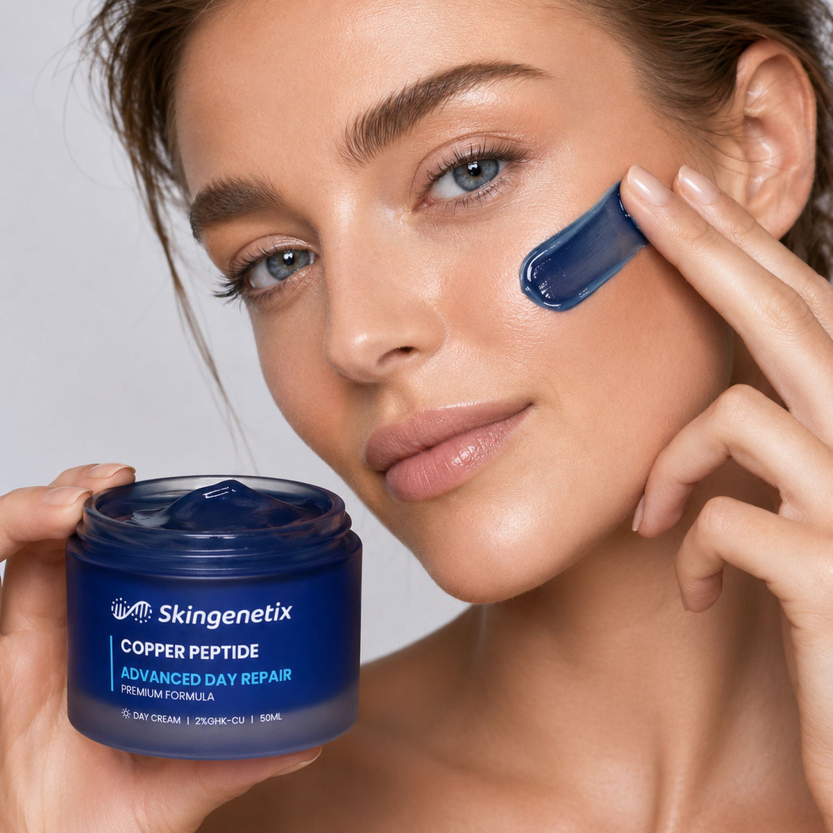 Skingenetix Copper Peptide (GHK-Cu) 2% Day Gel-Cream, 50ml - a model with the blue cream smoothed onto one cheek